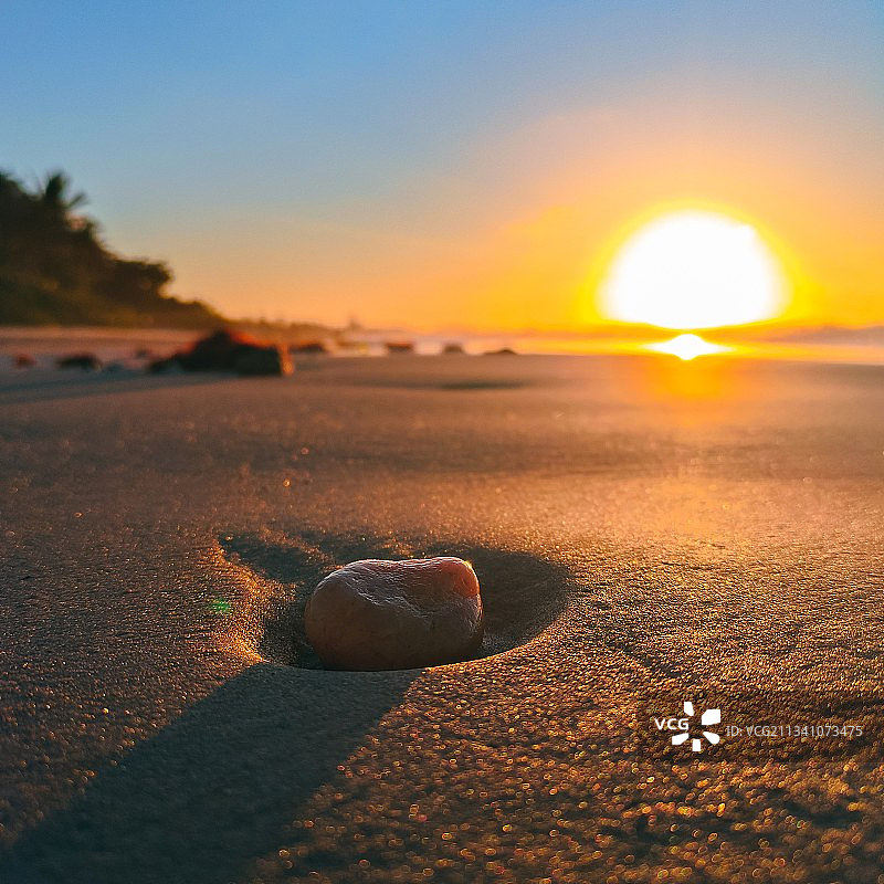 日落时海滩上卵石与天空的特写图片素材