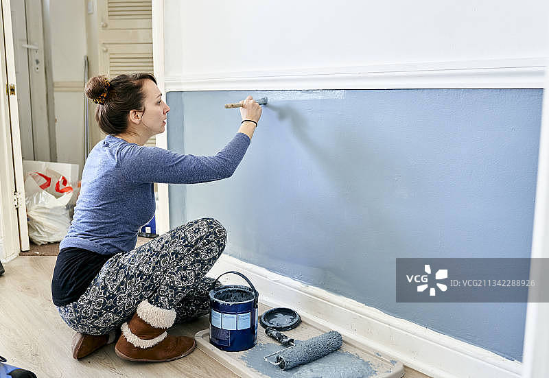 在家DIY，英国，妇女在家刷墙。图片素材