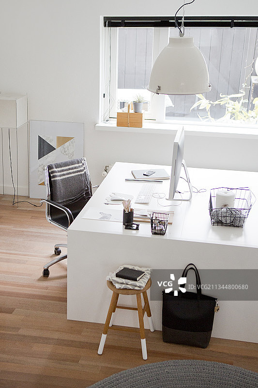 书房里白色的设计师书桌和黑色的转椅图片素材