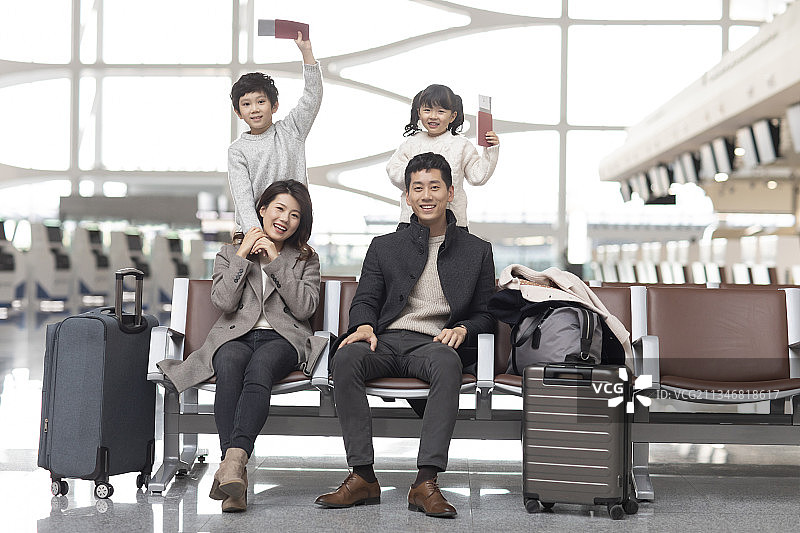 快乐的年轻家庭在机场候机图片素材
