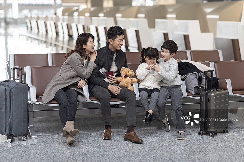 快乐的年轻家庭在机场候机图片素材