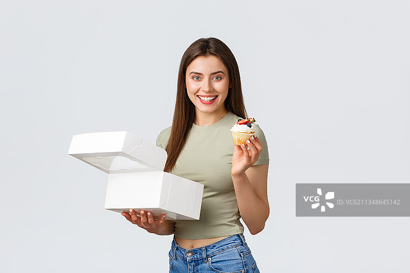 一名微笑的年轻女子手持盒子站在白色背景下图片素材