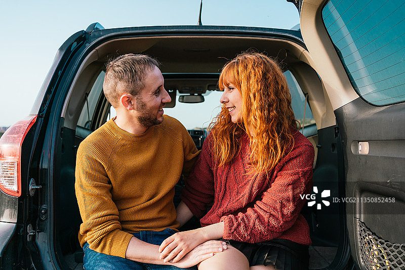 幸福的年轻夫妇坐在西班牙苏威的后备箱里图片素材