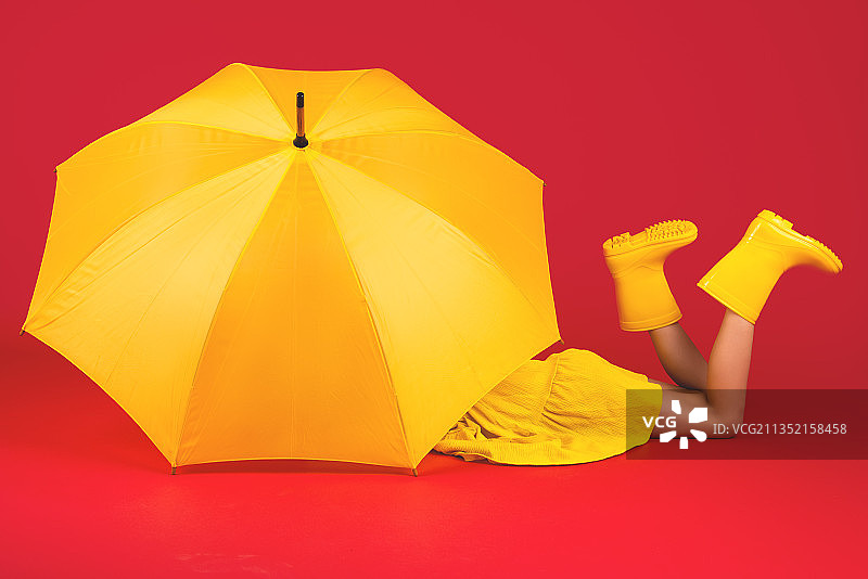 女孩穿着雨靴和伞在彩色背景图片素材