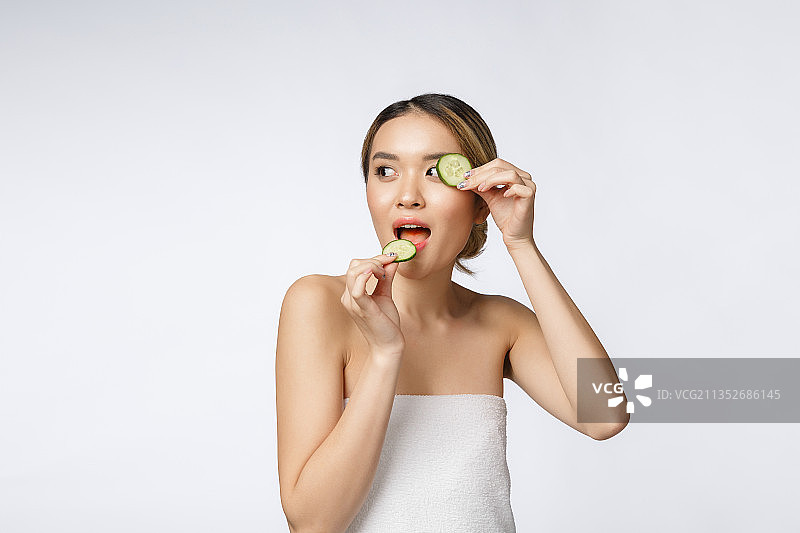 年轻女子在白色背景下进食的肖像图片素材