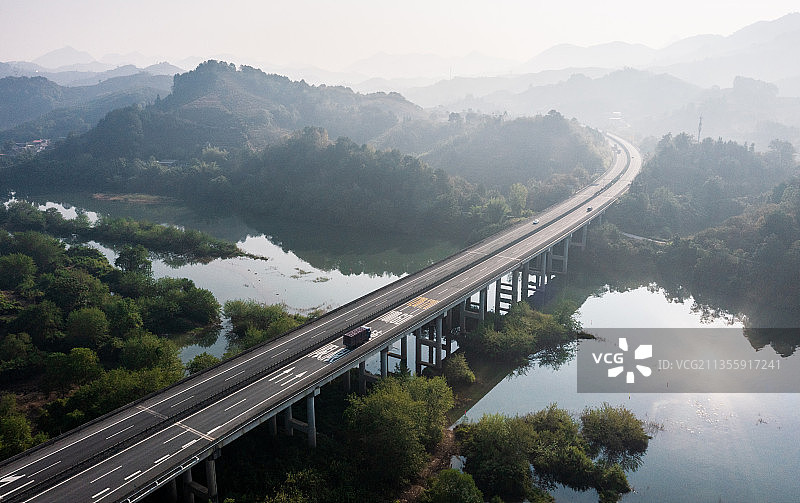 清晨日出时分山间河流上的高速公路高架桥图片素材