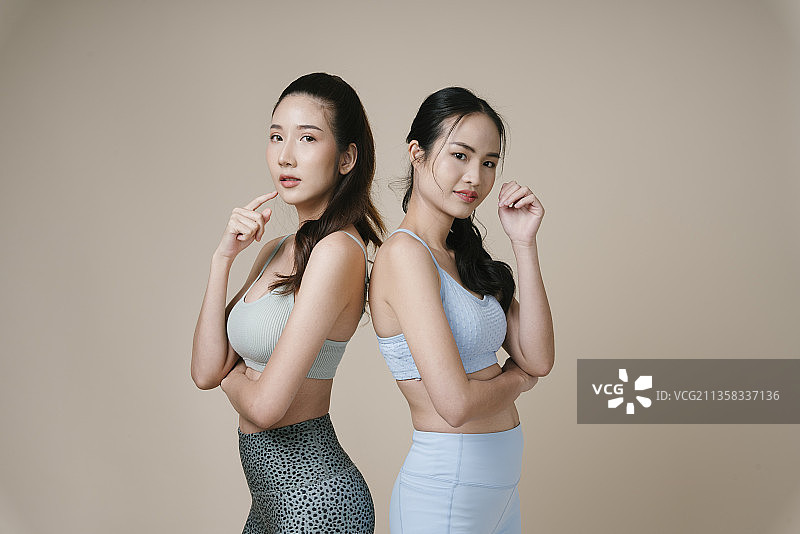 肖像的两个运动员亚洲运动妇女穿运动胸罩在工作室的灯光。图片素材
