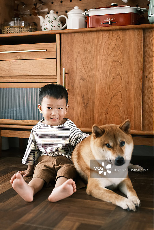 日系装修风格的住宅里一个男孩和宠物狗的合影图片素材