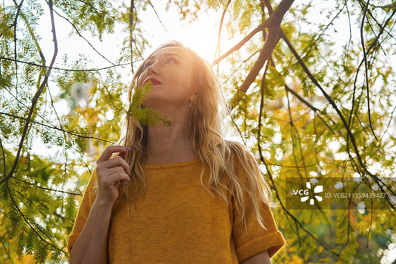 宁静的金发女子森林沐浴在秋天图片素材