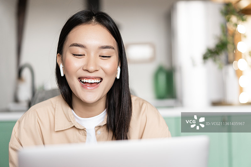 快乐微笑的亚洲女孩谈论笔记本电脑，视频会议学生图片素材