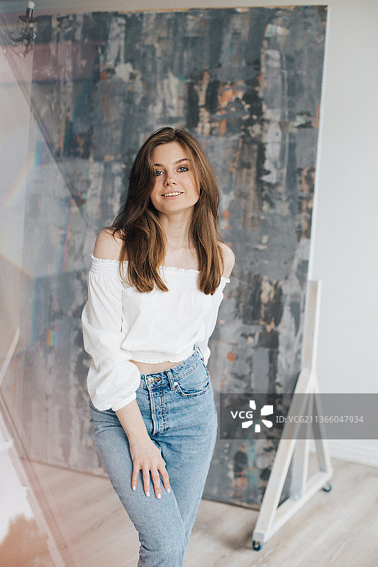 俄罗斯一家照相馆里，一个穿着白衬衫和蓝色牛仔裤的小女孩图片素材