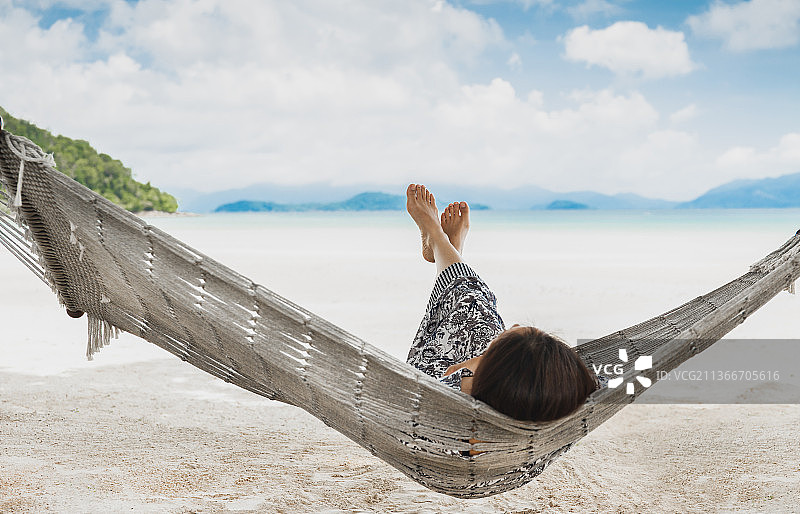 美丽时尚的女人躺在吊床与海景，泰国图片素材