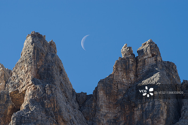 山峰间的月亮，在意大利威尼托蔚蓝的天空衬托下的低角度岩石构造图片素材