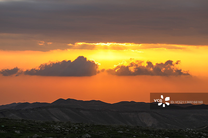 犹太沙漠峡谷美丽的日出，伴随着太阳的光芒图片素材