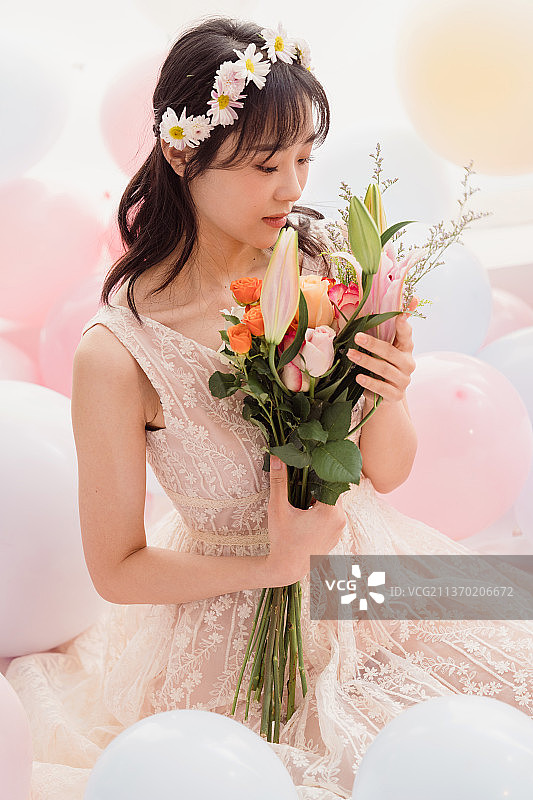 穿着婚纱的女孩坐在床上抱着花图片素材