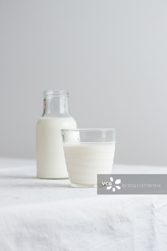 新鲜的牛奶和白色的桌布放在桌子上图片素材