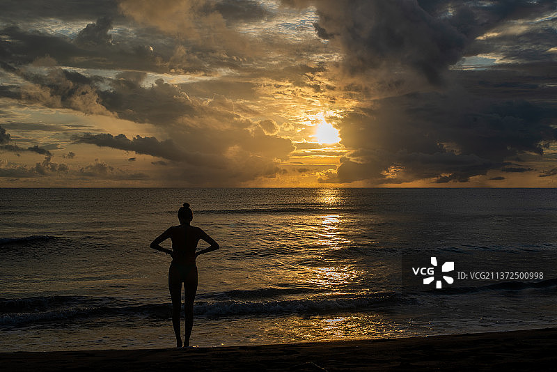 在哥斯达黎加享受日出，男人的剪影站在夕阳下的天空，托图盖罗，哥斯达黎加图片素材