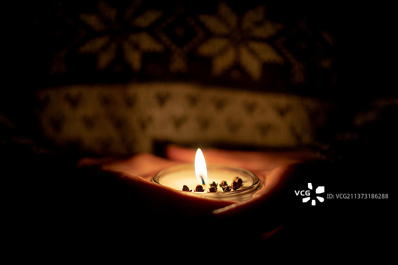 大豆蜡烛和小手在周围，在暗室里被点燃的迪娅的特写图片素材