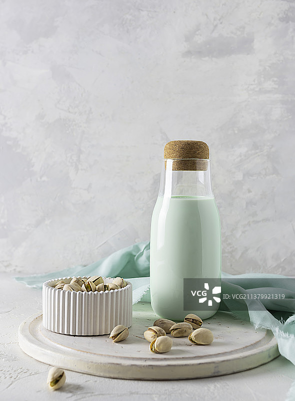 装开心果牛奶的玻璃瓶，放在轻板上图片素材