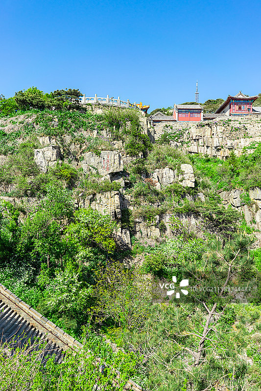 中国非都市风光拍摄主题，山东省泰安市国内著名景点泰山风景区，玉皇顶的山谷悬崖和蓝天，天阶上的古代建筑图片素材