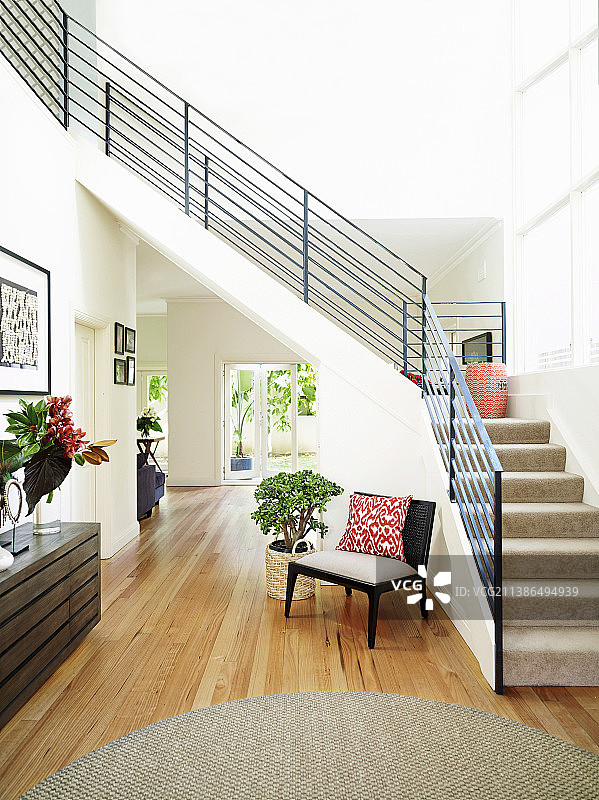 明亮的走廊，楼梯下的木地板和金属栏杆图片素材