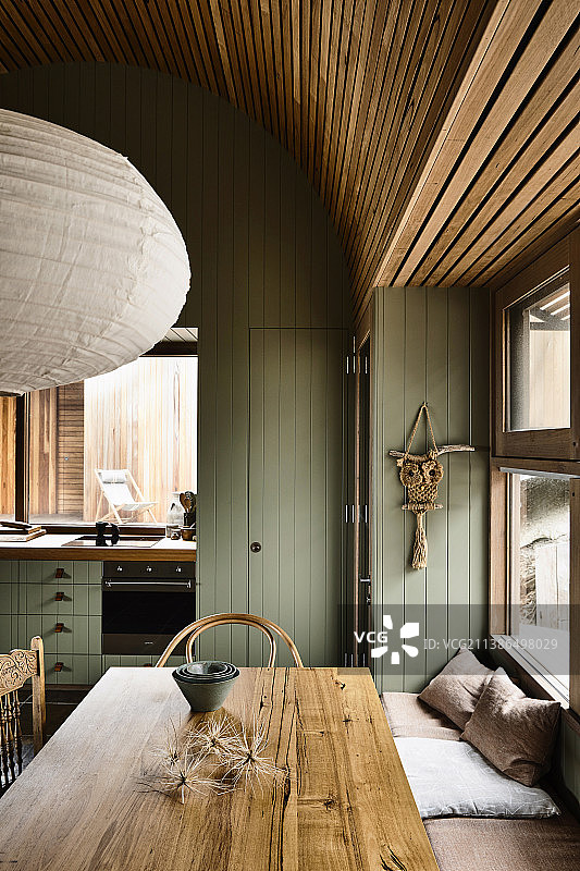 厨房靠窗的餐桌和长凳，绿色木镶板图片素材