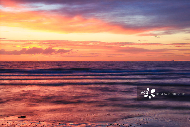 在比利时布里丁，日落时，大海映衬着戏剧性的天空的风景图片素材