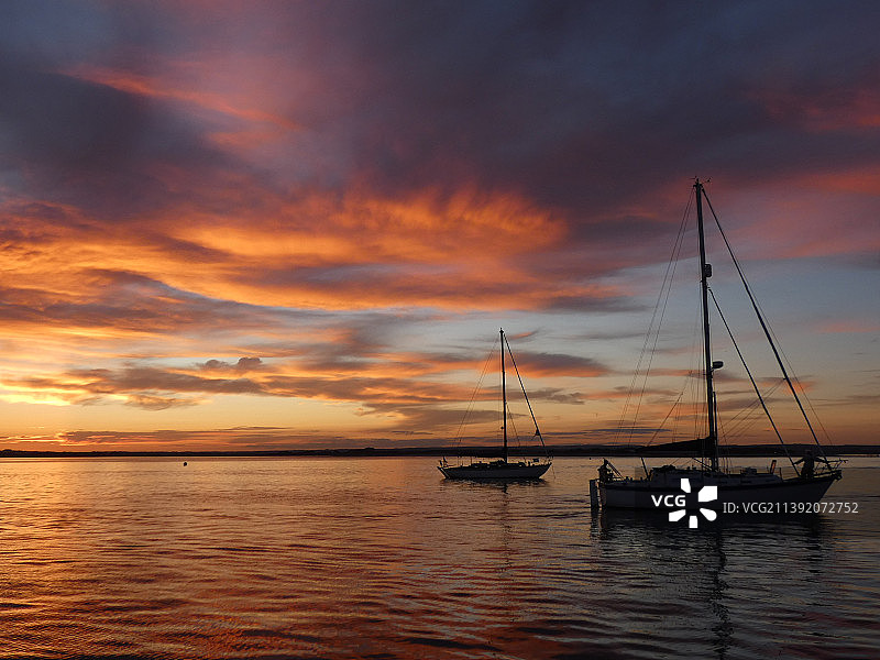 日落时海上帆船的剪影图片素材