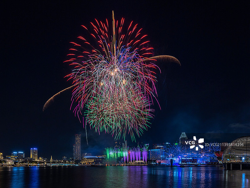 低角度的焰火显示在河对天空在晚上，滨海湾，新加坡图片素材