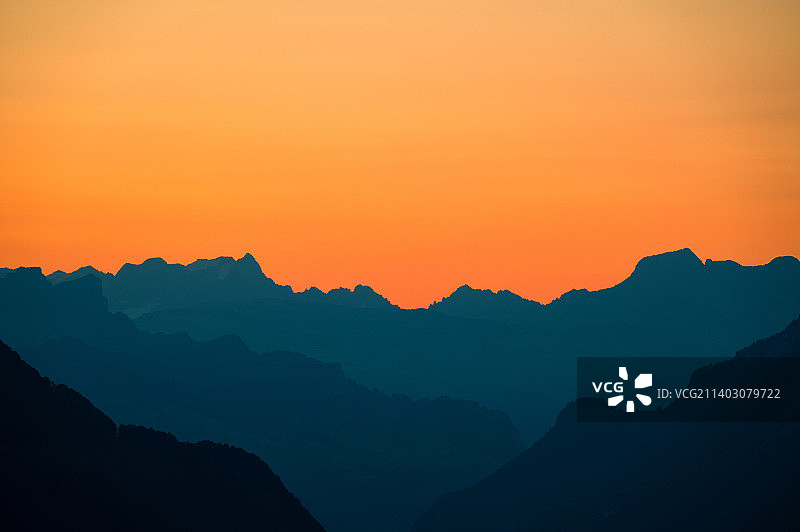 瑞士Honegg，橙色天空映衬下山脉轮廓的风景图片素材