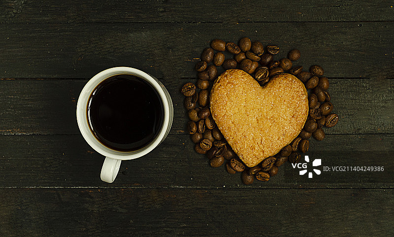 一杯咖啡和爱情饼干，木制表面的咖啡豆，俯瞰情人节假期图片素材