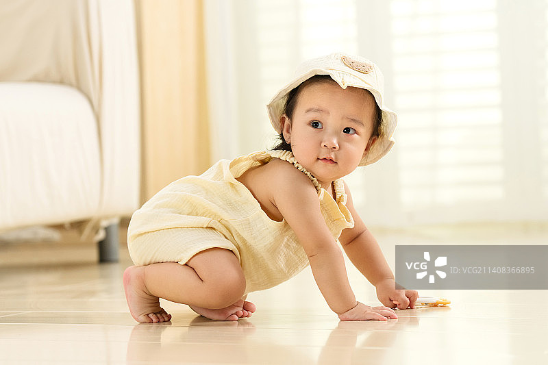 可爱的女宝宝坐在地板上玩耍图片素材