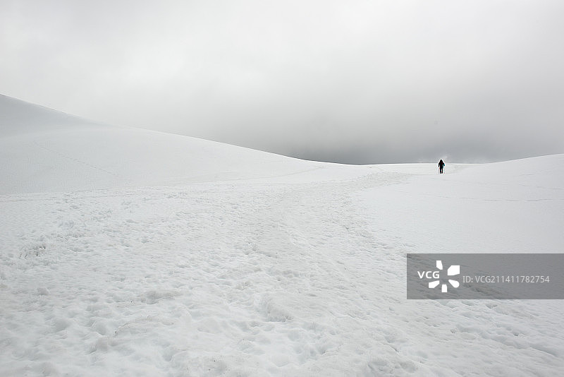 一名男子在雪地里徒步，意大利雷焦埃米利亚的米诺佐别墅图片素材