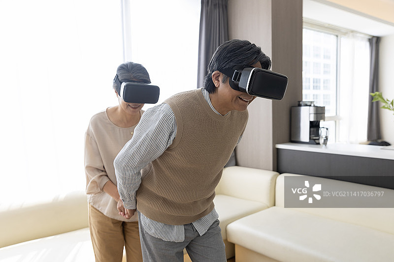 老年夫妻在客厅戴着3D智能眼镜玩游戏图片素材