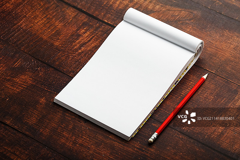 红色铅笔在棕色木桌背景的记事本，为教育，写下目标和行动，罗马尼亚图片素材