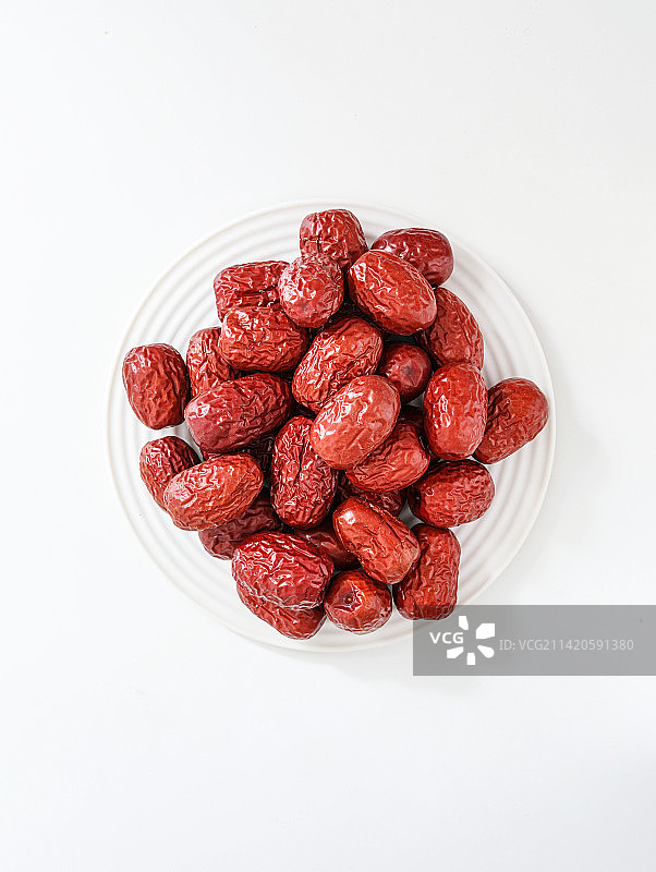 白色背景上的一碟子美食红枣图片素材