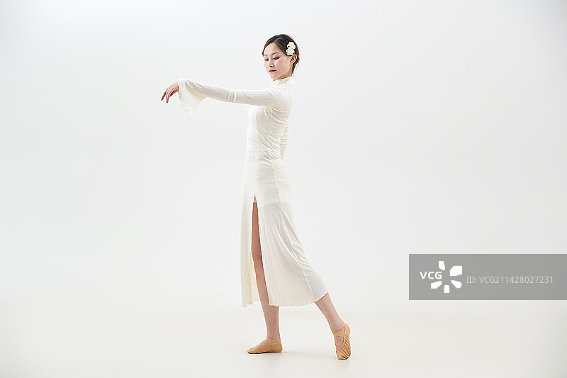 穿着白色旗袍头戴绢花的跳古典舞的少女图片素材