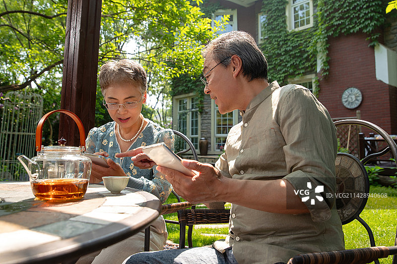 老年夫妇坐在院子里喝茶图片素材