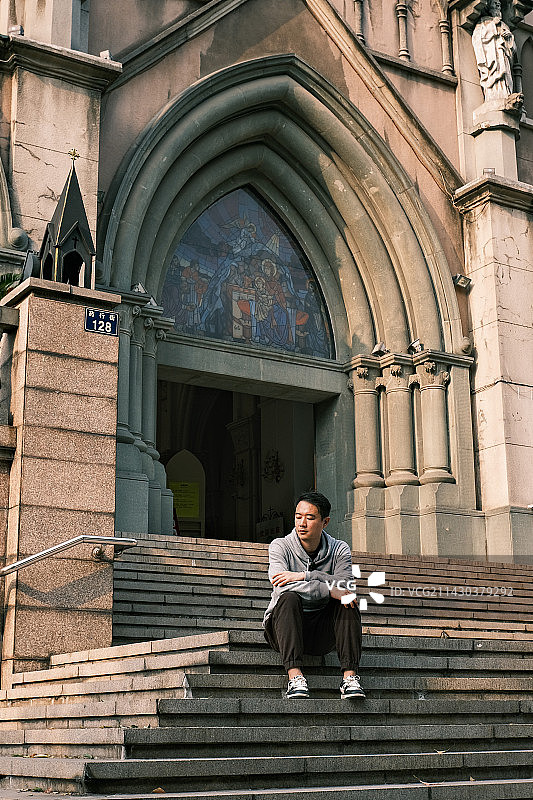 坐在宁波耶稣圣心堂门前石阶上休息的青年图片素材