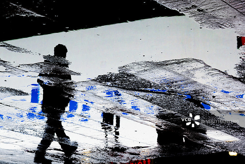 雨中行人的影子倒映在人行道上图片素材