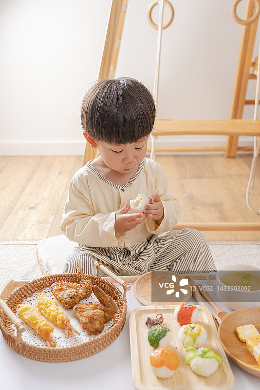 幼儿享受丰盛的手掬寿司天妇罗玉子烧美食图片素材