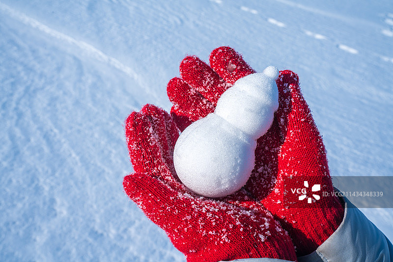 戴着红手套，拿着小雪人图片素材