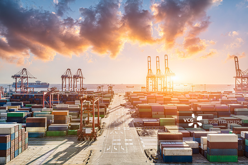 繁忙的集装箱港口和云景在日出时图片素材
