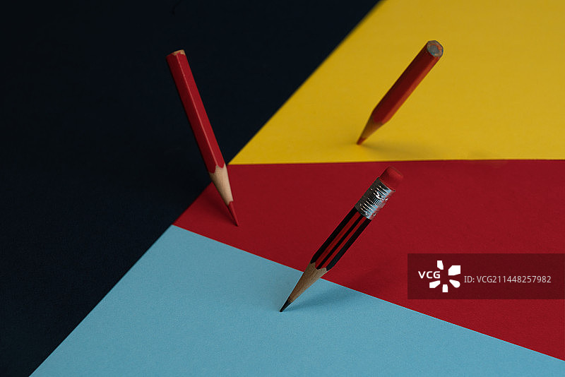 彩色铅笔在红黄蓝的纸上的高角度视图图片素材