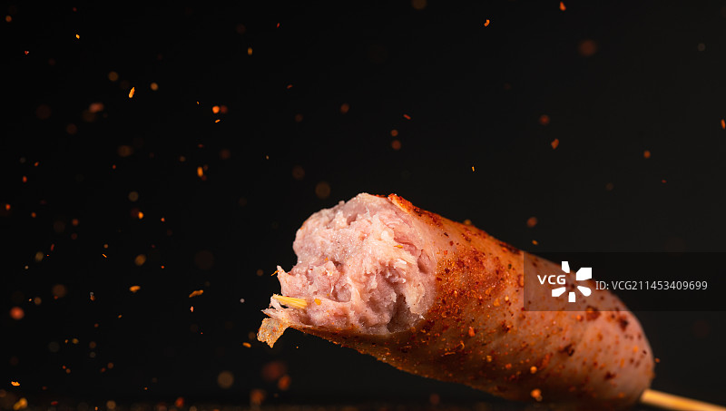 烤香肠在空中与辣椒粉飞行高速同步拍摄。图片素材