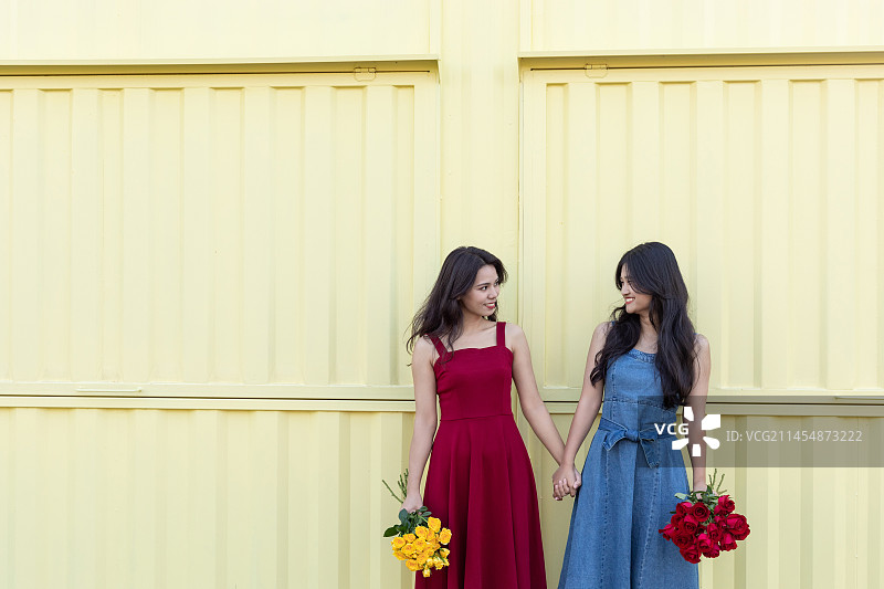 户外两名中国美女手拿着玫瑰花图片素材
