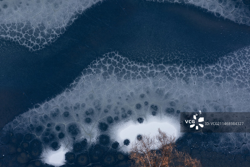 在空中俯瞰冬天尚未完全结冰的湖面图片素材