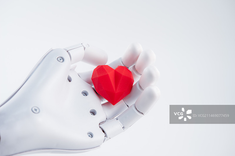 白色机械手手心捧着红色的心，人工智能ai关爱概念图片素材
