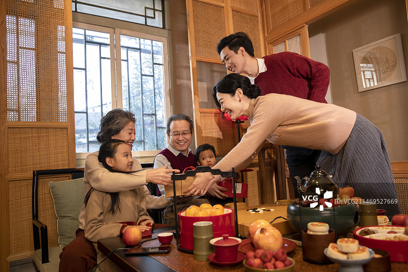 东方家庭过年：幸福一家人在客厅送春节礼物图片素材