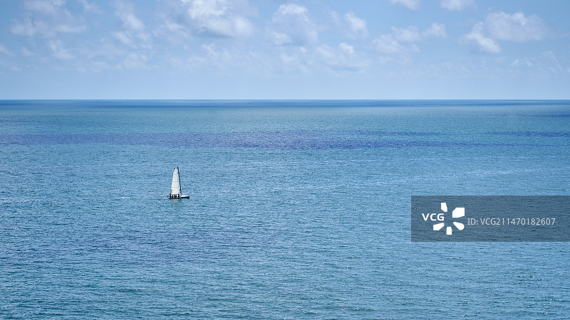 一艘白色帆船畅洋在蓝色大海上图片素材
